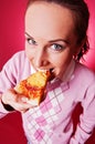 Happy young woman eating piece of pizza