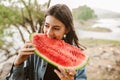 Young woman eating watermelon on a rainy summer day Royalty Free Stock Photo