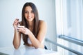 Happy young woman eating yogurt in kitchen Royalty Free Stock Photo