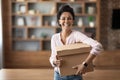 Happy young woman embracing box with something inside and smiling Royalty Free Stock Photo