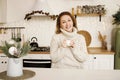 Happy young woman enjoying drinking tea or coffee in kitchen with Christmas decor over new year background Royalty Free Stock Photo