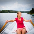 Happy, young woman enjoying rowing boat ride on a lake Royalty Free Stock Photo