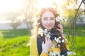 Happy young woman enjoying smell flowers over spring garden background