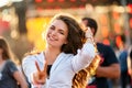 Happy young woman enjoys summer music fest on beach with sunset backlighting. Casual outfit, dancing on sand, joyous Royalty Free Stock Photo