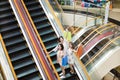 Happy young woman on escalator in shopping mall Royalty Free Stock Photo