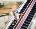 Happy young woman on escalator in shopping mall Royalty Free Stock Photo