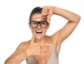 Happy young woman in eyeglasses framing with hands