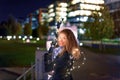 Happy young woman with fairy lights looking back in city night Royalty Free Stock Photo