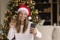 Happy young woman in festive mood holding videocall on cellphone. Royalty Free Stock Photo