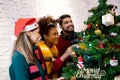 Happy young woman and friends decorating and preparation ornament on Christmas tree with enjoy at home. Royalty Free Stock Photo