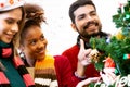 Happy young woman and friends decorating and preparation ornament on Christmas tree with enjoy at home. Royalty Free Stock Photo