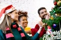 Happy young woman and friends decorating and preparation ornament on Christmas tree with enjoy at home. Royalty Free Stock Photo