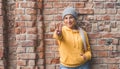 Happy young woman gesturing with fingers. Outdoors daylight. Lovely girl gesturing V sign Royalty Free Stock Photo