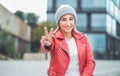 Happy young woman gesturing with fingers. Outdoors daylight. Lovely girl gesturing V sign Royalty Free Stock Photo