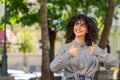 Happy young woman girl showing thumbs up like sign something good positive feedback on city street Royalty Free Stock Photo