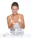 Happy young woman with glass bowl with water washing hands