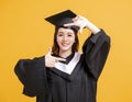 Happy young woman in graduation gowns with looking gesture Royalty Free Stock Photo