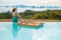 Happy young woman in green swimsuit having Floating Breakfast tray in luxury pool hotel, girl with hat enjoy in tropical resort. Royalty Free Stock Photo