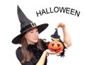 Happy young woman in a Halloween witch costume holding a pumpkin on a white background. Party, Celebration. The concept of the Royalty Free Stock Photo