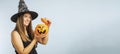 Happy young woman in halloween witch costume with pumpkin basket jack-o-lantern Royalty Free Stock Photo