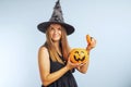 Happy young woman in halloween witch costume with pumpkin basket jack-o-lantern Royalty Free Stock Photo