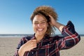 Happy young woman with hand in curly hair at the beach Royalty Free Stock Photo