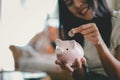 Happy young woman and hand putting coin into piggy bank, Finance or Savings concept. Royalty Free Stock Photo