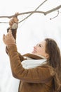 Happy young woman hanging bird feeder on tree Royalty Free Stock Photo