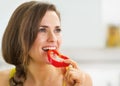 Happy young woman having a bite of red bell pepper Royalty Free Stock Photo