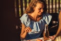 Happy young woman having dinner at the table outdoors on a picnic, summer time concept, barbecue Royalty Free Stock Photo