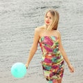 Happy young woman having fun with colorful latex balloon