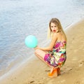 Happy young woman having fun with colorful latex balloon