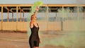 Happy young woman having fun with colorful powder cloud. girl running with yellow color smoke bomb Royalty Free Stock Photo