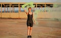 Happy young woman having fun with colorful powder cloud. girl running with yellow color smoke bomb Royalty Free Stock Photo