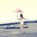 Happy young woman having fun with colorful an umbrella.
