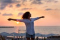 Happy young woman having fun with open hands at the sunset on sea. Royalty Free Stock Photo