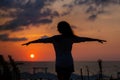 Happy young woman having fun with open hands at the sunset on sea. Royalty Free Stock Photo