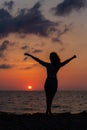 Happy young woman having fun with open hands at the sunset on sea. Royalty Free Stock Photo