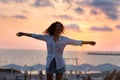 Happy young woman having fun with open hands at the sunset on sea. Royalty Free Stock Photo