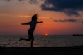 Happy young woman having fun with open hands at the sunset on sea. Royalty Free Stock Photo