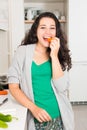 Happy young woman having a healthy snack while cooking