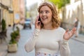 Happy young woman having remote conversation talking on smartphone good news gossip in city street Royalty Free Stock Photo