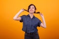 Happy young woman happy about her shampoo for her demaged hair in studio over yellow background Royalty Free Stock Photo