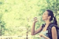 Happy young woman hiker with backpack drinking bottled water