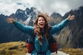 Happy young woman hiker with raised hands on top of a mountain, rear view Backpacker woman feeling freedom in a spectacular