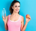 Happy young woman holding apple and water Royalty Free Stock Photo