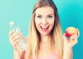 Happy young woman holding apple and water Royalty Free Stock Photo