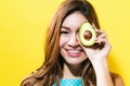 Happy young woman holding avocado halve