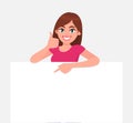 Happy young woman holding a blank / empty sheet of white paper or board and gesturing thumbs up sign. Royalty Free Stock Photo