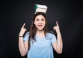 Happy young woman holding books on her head Royalty Free Stock Photo